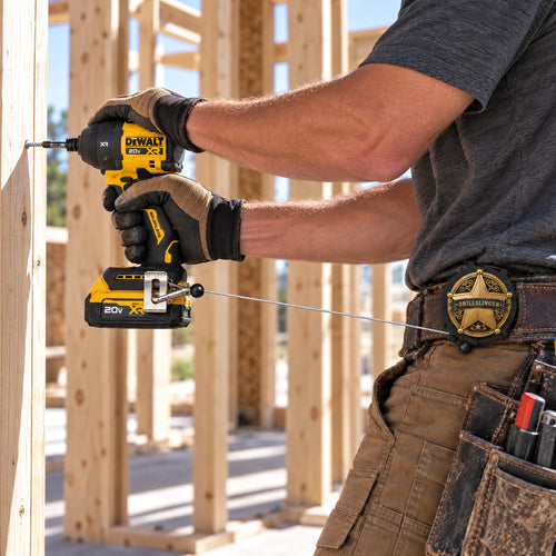 Worker driving a screw with the drill tethered to the Drillslinger on his belt